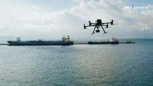 dron volando sobre el agua con barcos de fondo