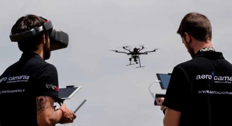 dos chicos con mando con pantalla volando un dron